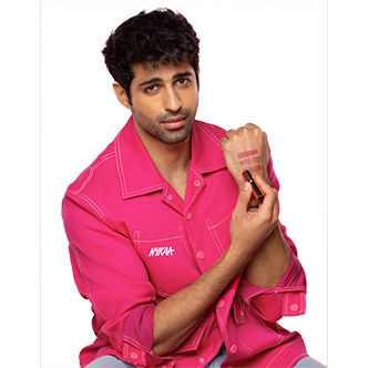 Aashim Gulati in pink swatching nude lipsticks on the back of his palm