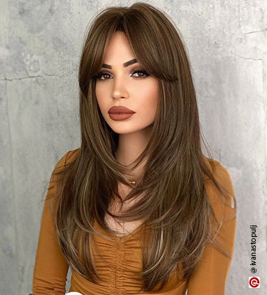 woman with a full face of makeup and brown lipstick with long hair