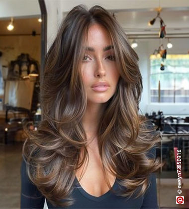  WOman in a black top with long layered hair