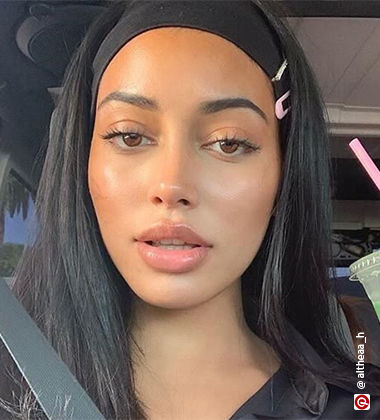 woman with pink clips in her hair in a car