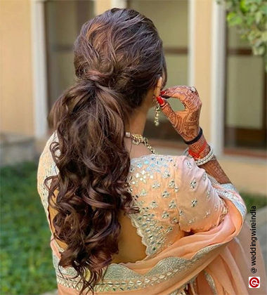 woman touching her ear with her hand with a pony