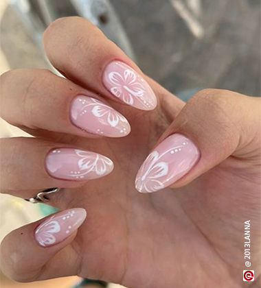 baby pink nails with maroon flowers on it
