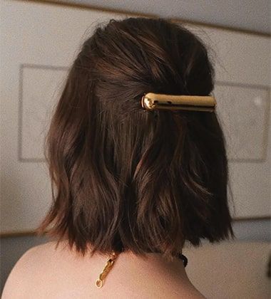 the back shot of a woman with golden buckle in her hair