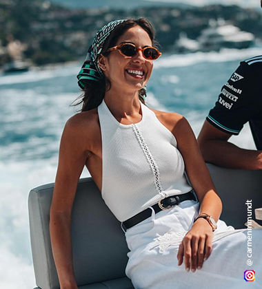 women sitting in a white dress and with a river and mountains in the background