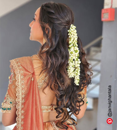 woman with loose waves and gajra in her hair
