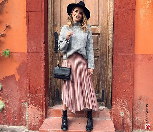 Woman in a grey sweater and pink skirt