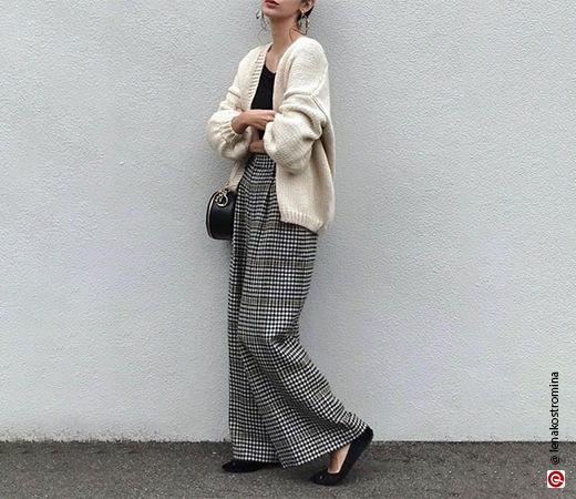 Woman wearing white cardigan with plaid trousers