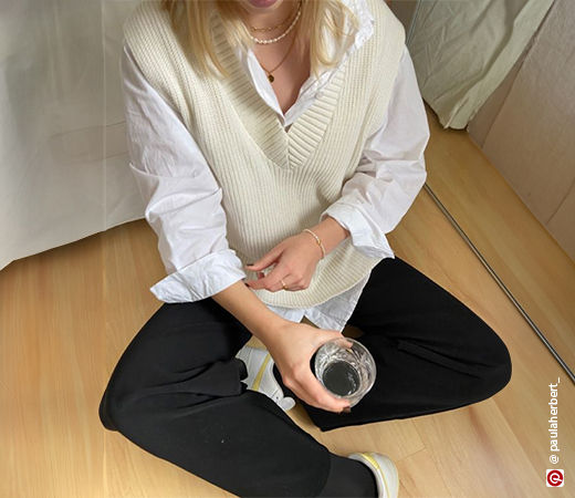Woman wearing a white shirt with a sweater vest