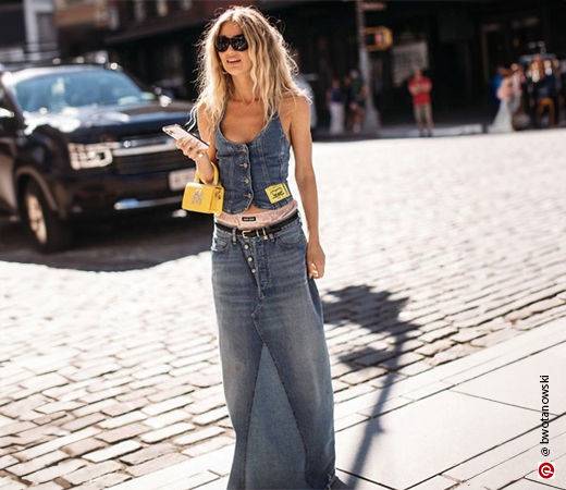 Woman wearing denim maxi skirt with a denim vest
            